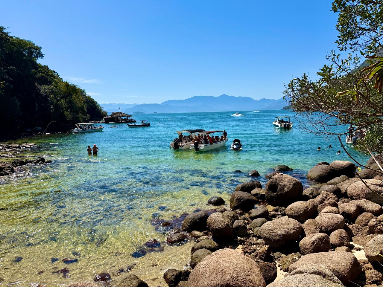 View of the beach, clear waters, rocks and boats